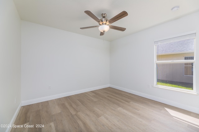 empty room with ceiling fan and light hardwood / wood-style flooring