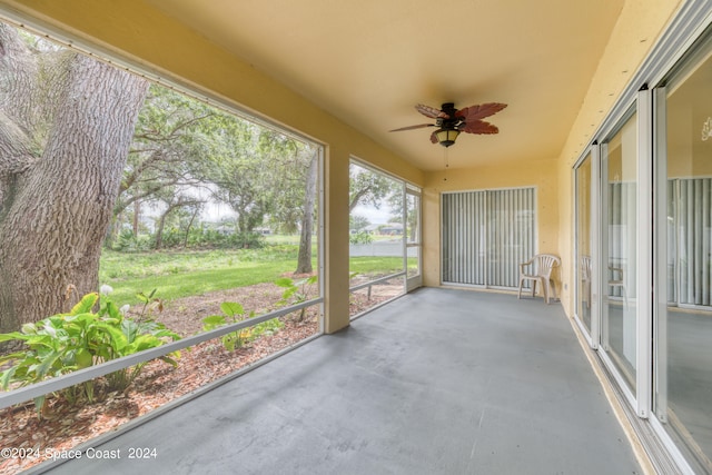 unfurnished sunroom featuring ceiling fan and a healthy amount of sunlight