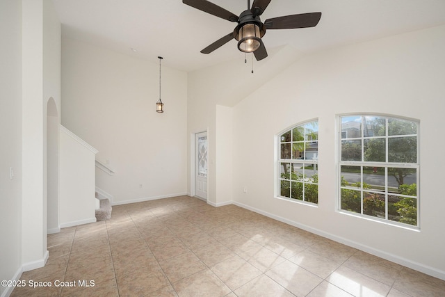 unfurnished living room featuring high vaulted ceiling, light tile patterned flooring, and ceiling fan