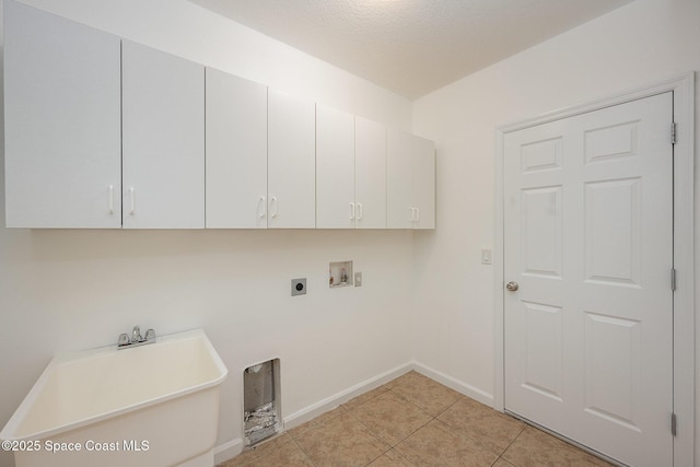 washroom featuring sink, hookup for a washing machine, light tile patterned floors, electric dryer hookup, and cabinets