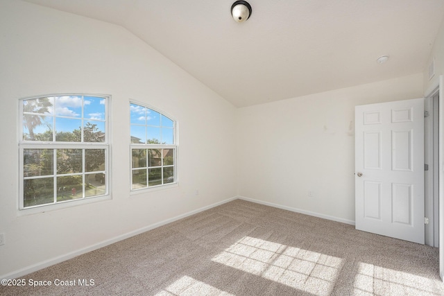 carpeted spare room with lofted ceiling