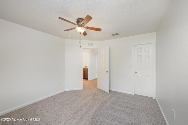 unfurnished bedroom featuring ceiling fan, light colored carpet, and a textured ceiling