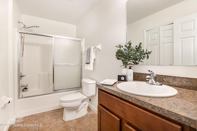 full bathroom featuring combined bath / shower with glass door, vanity, toilet, and a textured ceiling