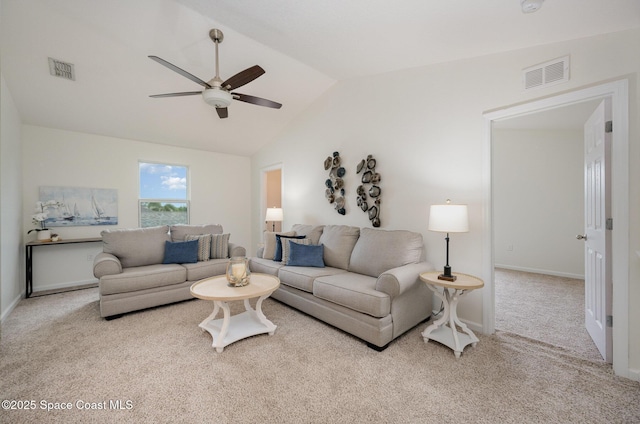 carpeted living room with ceiling fan and vaulted ceiling