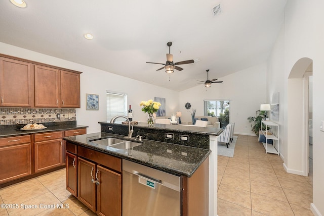 kitchen featuring lofted ceiling, dark stone countertops, sink, a kitchen island with sink, and stainless steel dishwasher