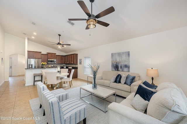 living room featuring ceiling fan, light tile patterned floors, and vaulted ceiling