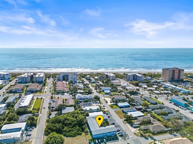 birds eye view of property with a water view and a beach view