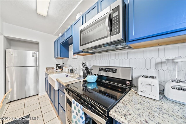 kitchen with blue cabinets, sink, and appliances with stainless steel finishes