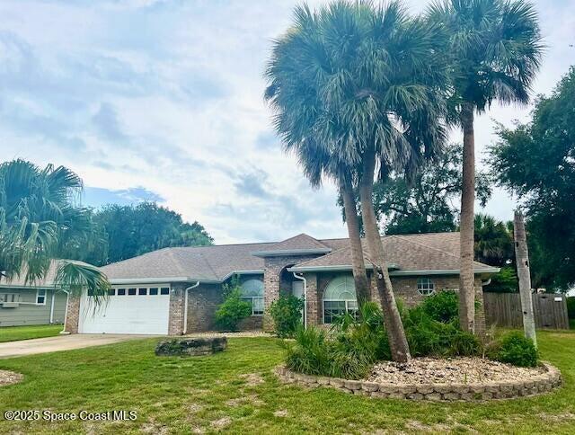 single story home featuring a garage and a front lawn