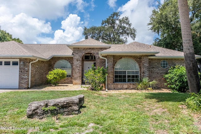 ranch-style house featuring a front yard and a garage