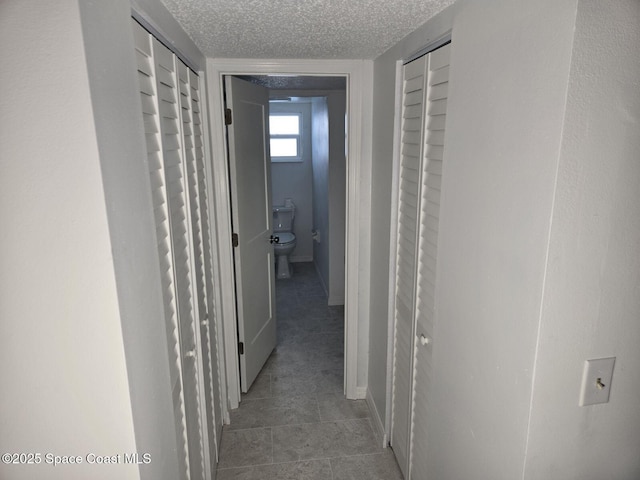 hallway with a textured ceiling