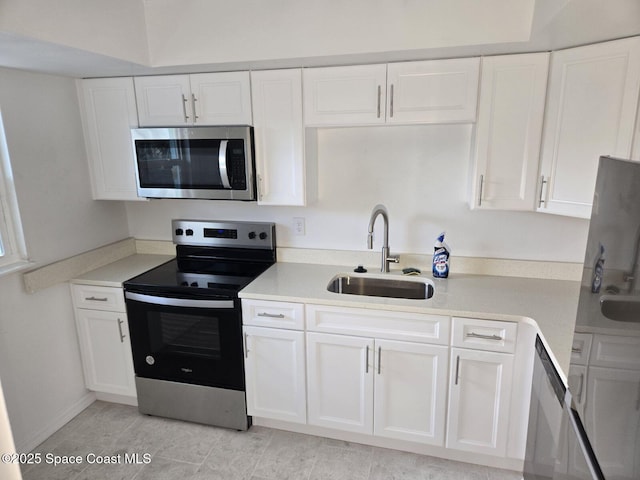 kitchen featuring light tile patterned floors, stainless steel appliances, white cabinetry, and sink