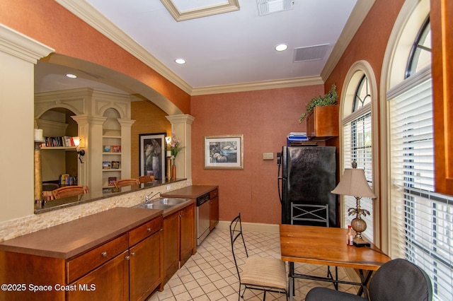 kitchen with kitchen peninsula, ornate columns, black fridge, stainless steel dishwasher, and sink