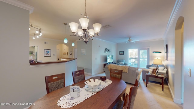 dining space with ceiling fan with notable chandelier, light colored carpet, and ornamental molding