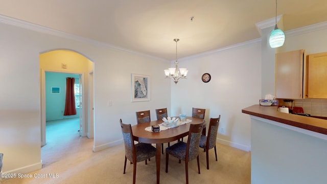 dining room with an inviting chandelier, light colored carpet, and ornamental molding