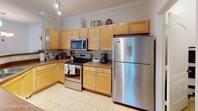 kitchen with appliances with stainless steel finishes, light brown cabinets, and hanging light fixtures