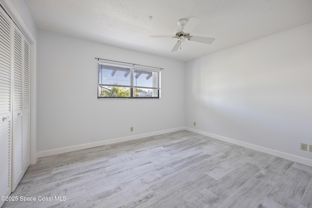 unfurnished bedroom with light wood-type flooring, ceiling fan, and a closet