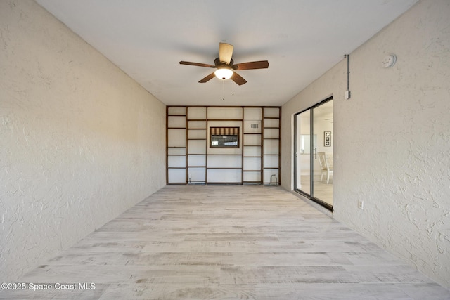 spare room with ceiling fan and light wood-type flooring