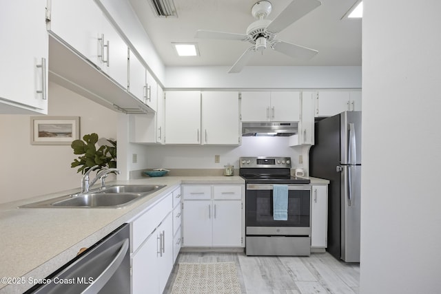 kitchen featuring ceiling fan, appliances with stainless steel finishes, white cabinets, light hardwood / wood-style flooring, and sink