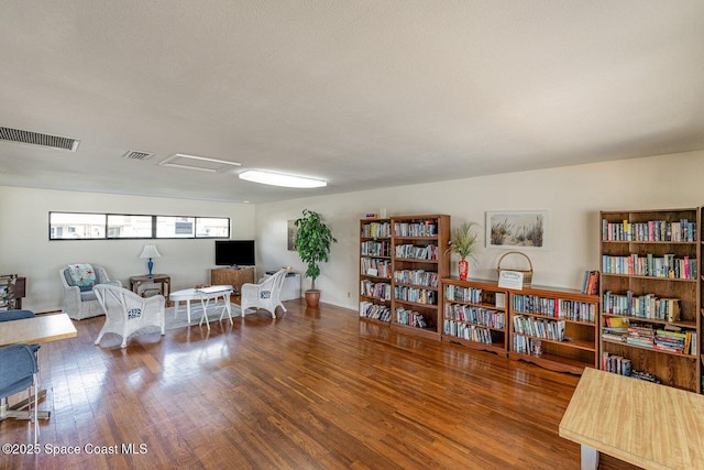 sitting room with wood-type flooring and a textured ceiling