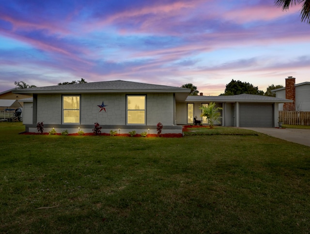 ranch-style home with a garage and a yard