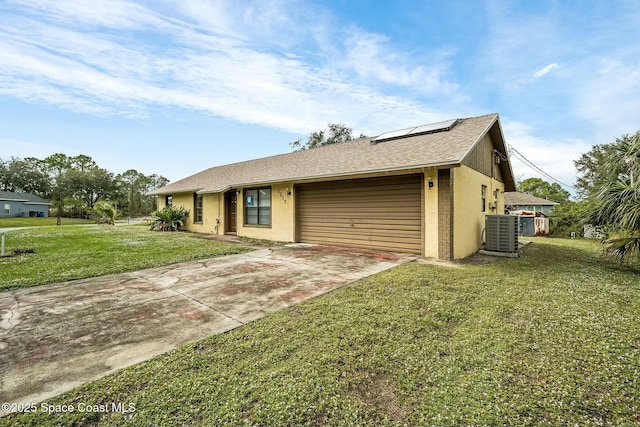 ranch-style house featuring solar panels, a garage, central air condition unit, and a front yard