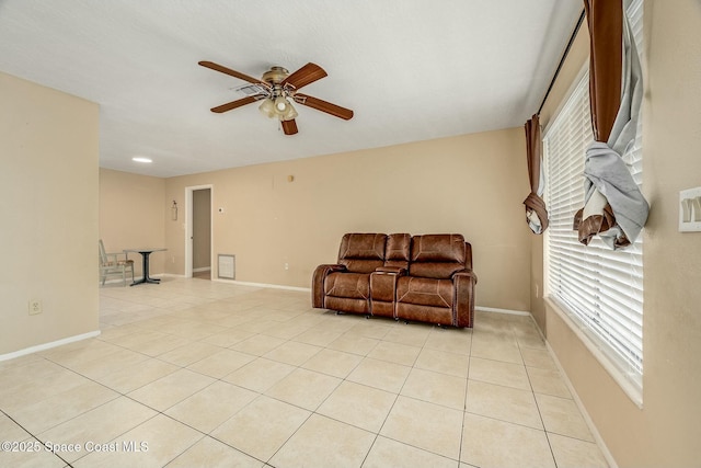 living area with light tile patterned floors and ceiling fan