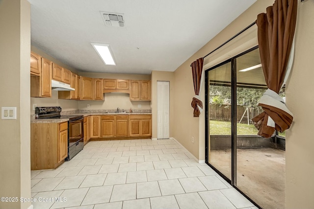 kitchen featuring black electric range oven, light tile patterned floors, and sink