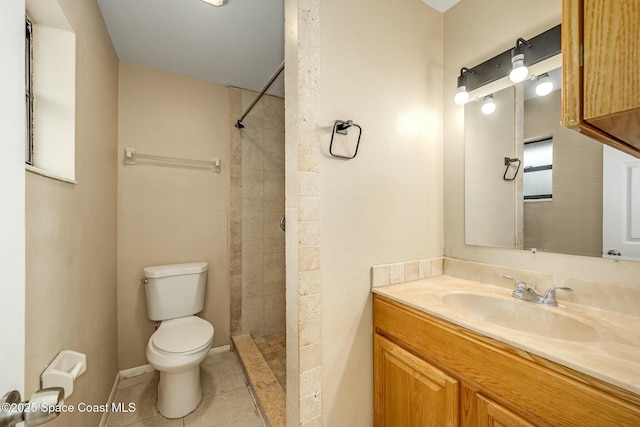 bathroom featuring tiled shower, tile patterned flooring, vanity, and toilet