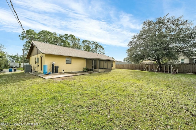 back of house with a patio area, a sunroom, a yard, and central AC unit