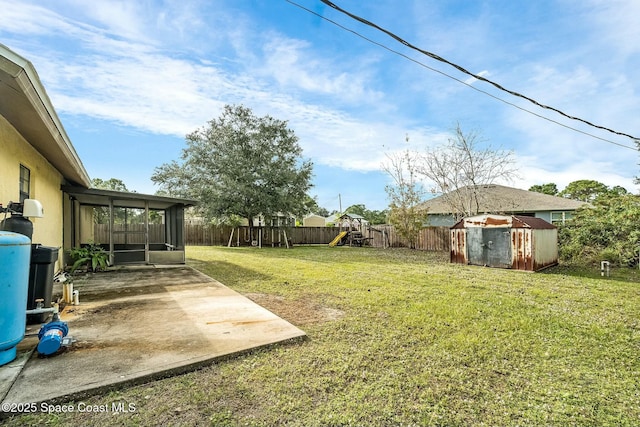 view of yard featuring a playground, a patio area, and a sunroom