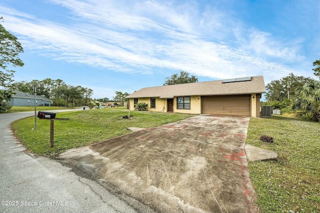 single story home featuring solar panels, a garage, cooling unit, and a front lawn