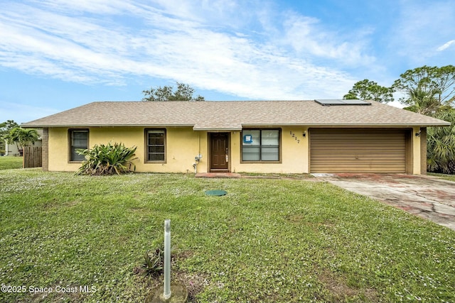 ranch-style home featuring a garage and a front lawn