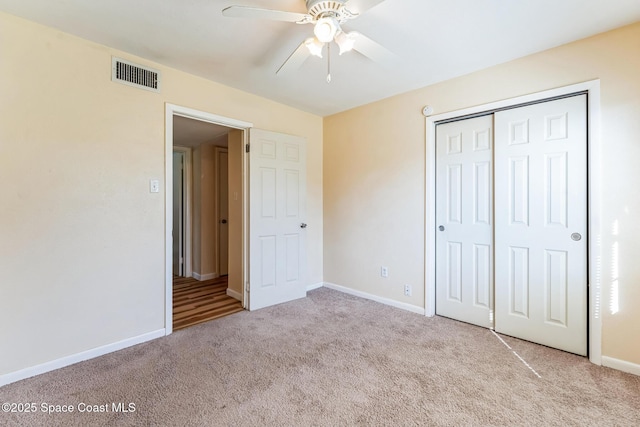 unfurnished bedroom with ceiling fan, a closet, and light colored carpet