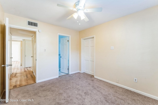 unfurnished bedroom featuring light carpet and ceiling fan