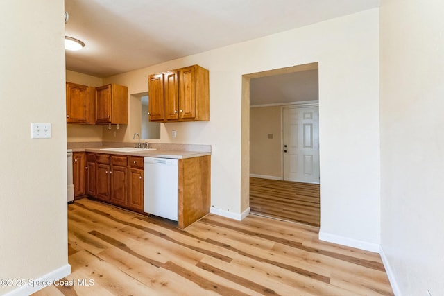 kitchen with dishwasher, light wood-type flooring, and sink