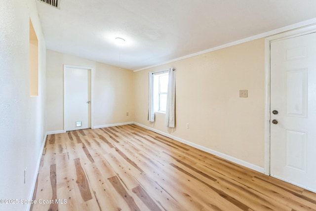 unfurnished room featuring ornamental molding, lofted ceiling, and light wood-type flooring