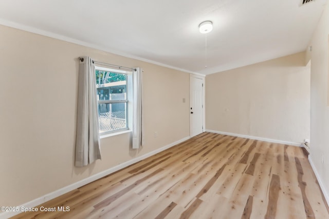 empty room with light hardwood / wood-style flooring and ornamental molding