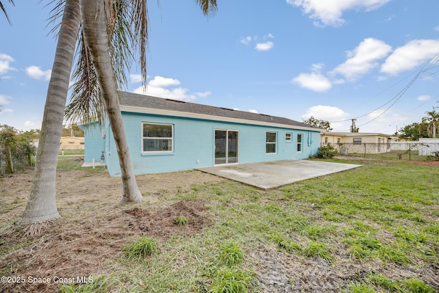 rear view of property featuring a lawn and a patio area