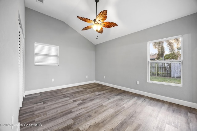 unfurnished room featuring hardwood / wood-style flooring, plenty of natural light, ceiling fan, and vaulted ceiling