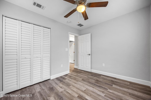 unfurnished bedroom featuring ceiling fan, wood-type flooring, and a closet