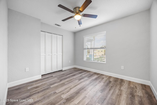 unfurnished bedroom with ceiling fan, a closet, and light hardwood / wood-style floors