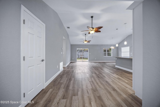 unfurnished living room with ceiling fan, wood-type flooring, and lofted ceiling