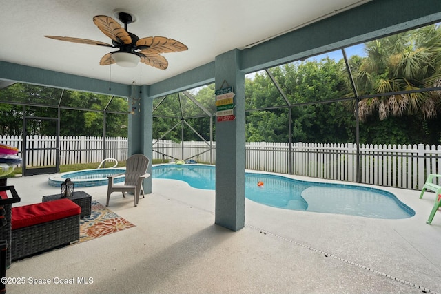 view of pool featuring an in ground hot tub, glass enclosure, ceiling fan, and a patio area