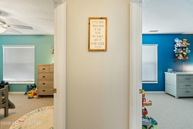 carpeted bedroom with ceiling fan and a textured ceiling