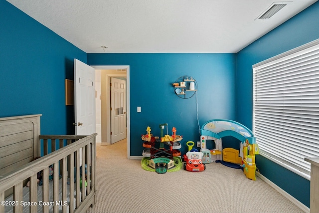 carpeted bedroom featuring a crib