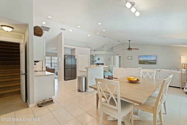 dining space featuring ceiling fan, lofted ceiling, and light tile patterned floors