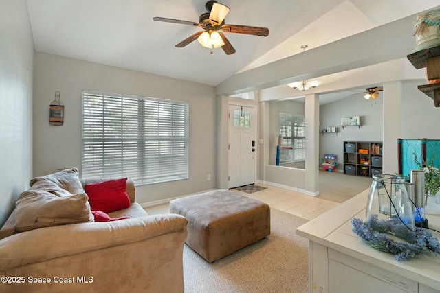 carpeted living room with ceiling fan and vaulted ceiling