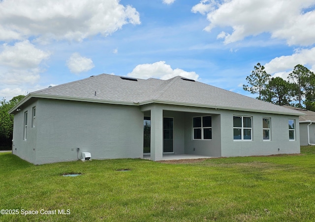 rear view of house with a lawn and a patio