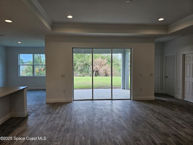 interior space with crown molding, dark wood-type flooring, and a tray ceiling